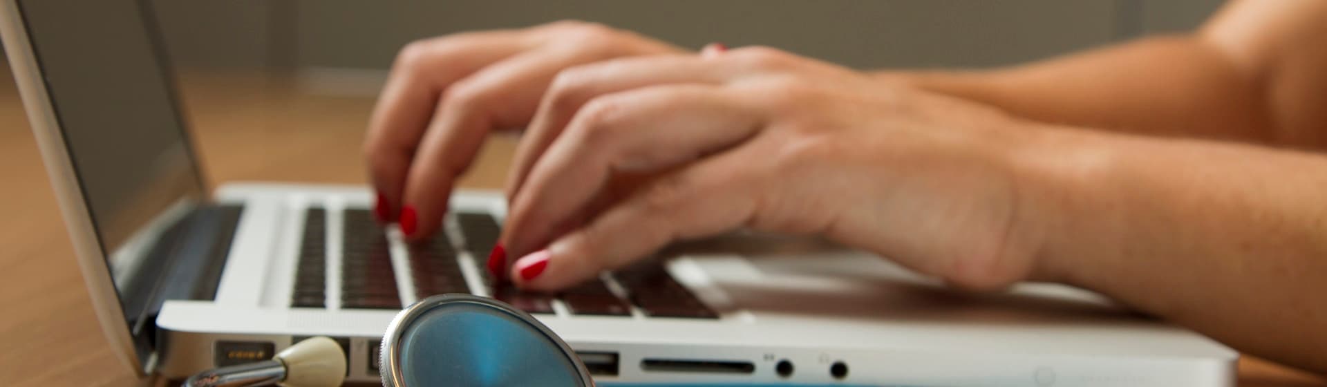 Healthcare professional working at a laptop